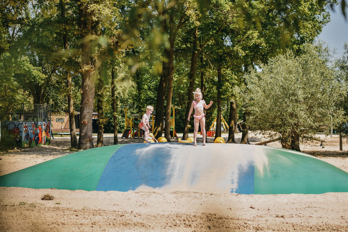 Kinderen op een springkussen van Camping de Rammelbeek