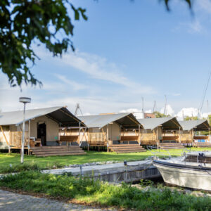 Vier glampingtenten naast elkaar aan de haven van Minicamping Marina Warns.