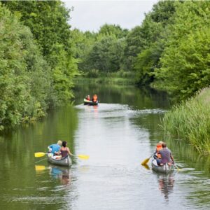 Mensen kanoën op een rivier bij Vestbirk Camping.